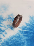 Wooden ring with lichen in resin on a abstract blue background