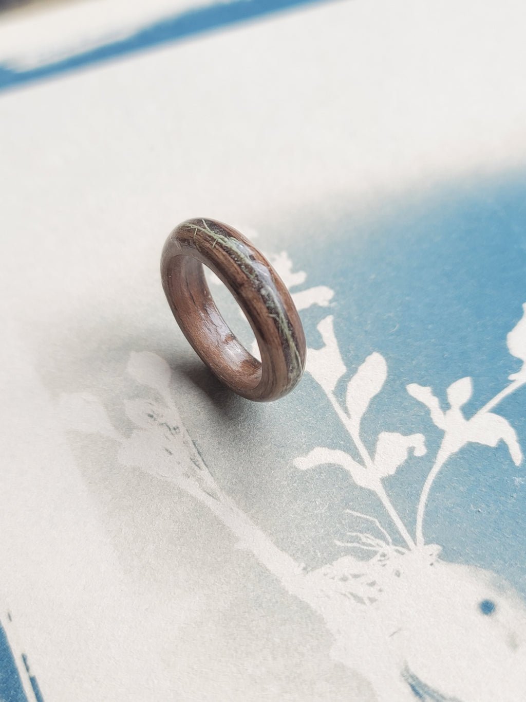 Wooden ring on a textured surface with floral design