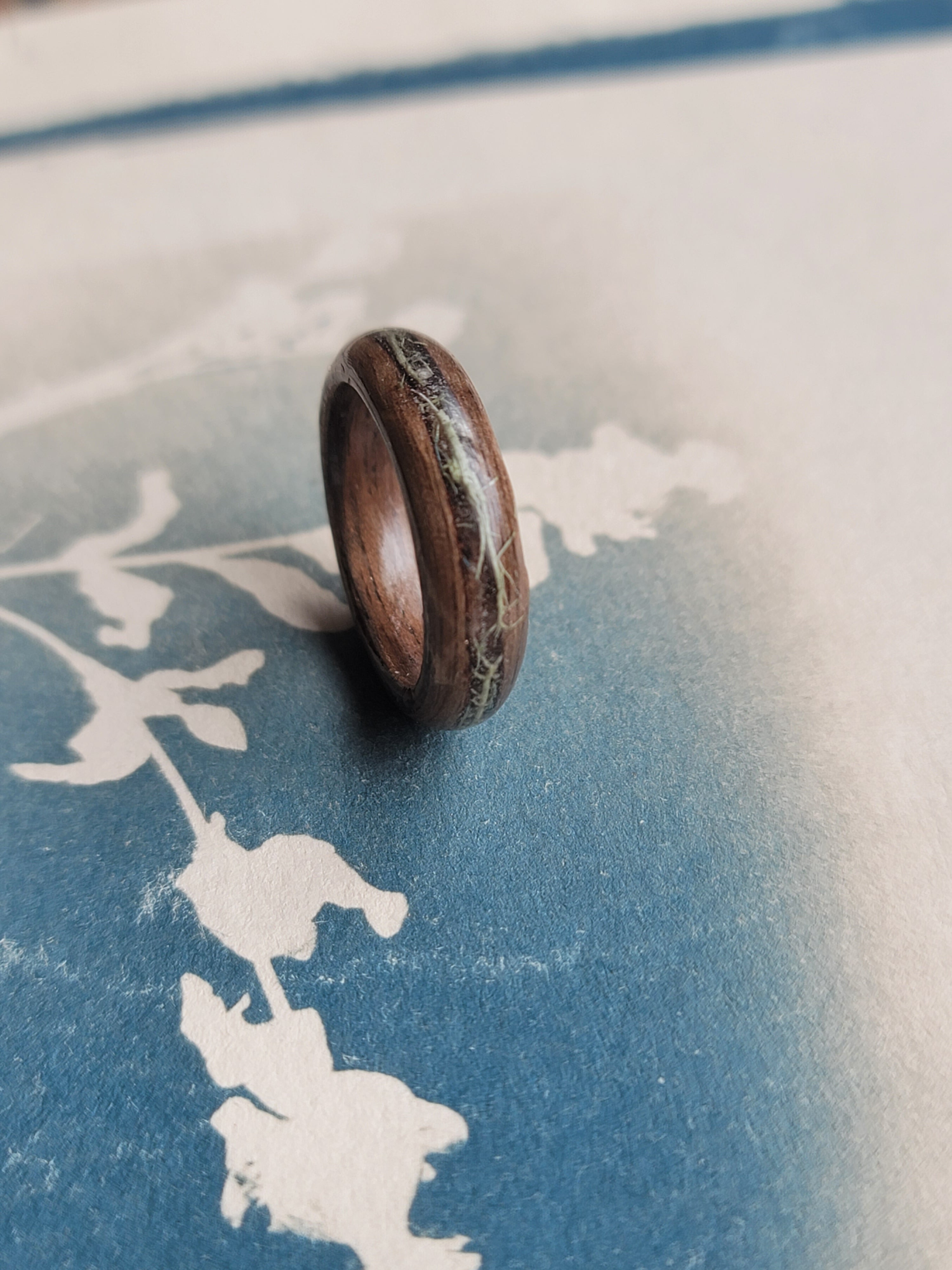 Wooden ring on a textured blue and white surface