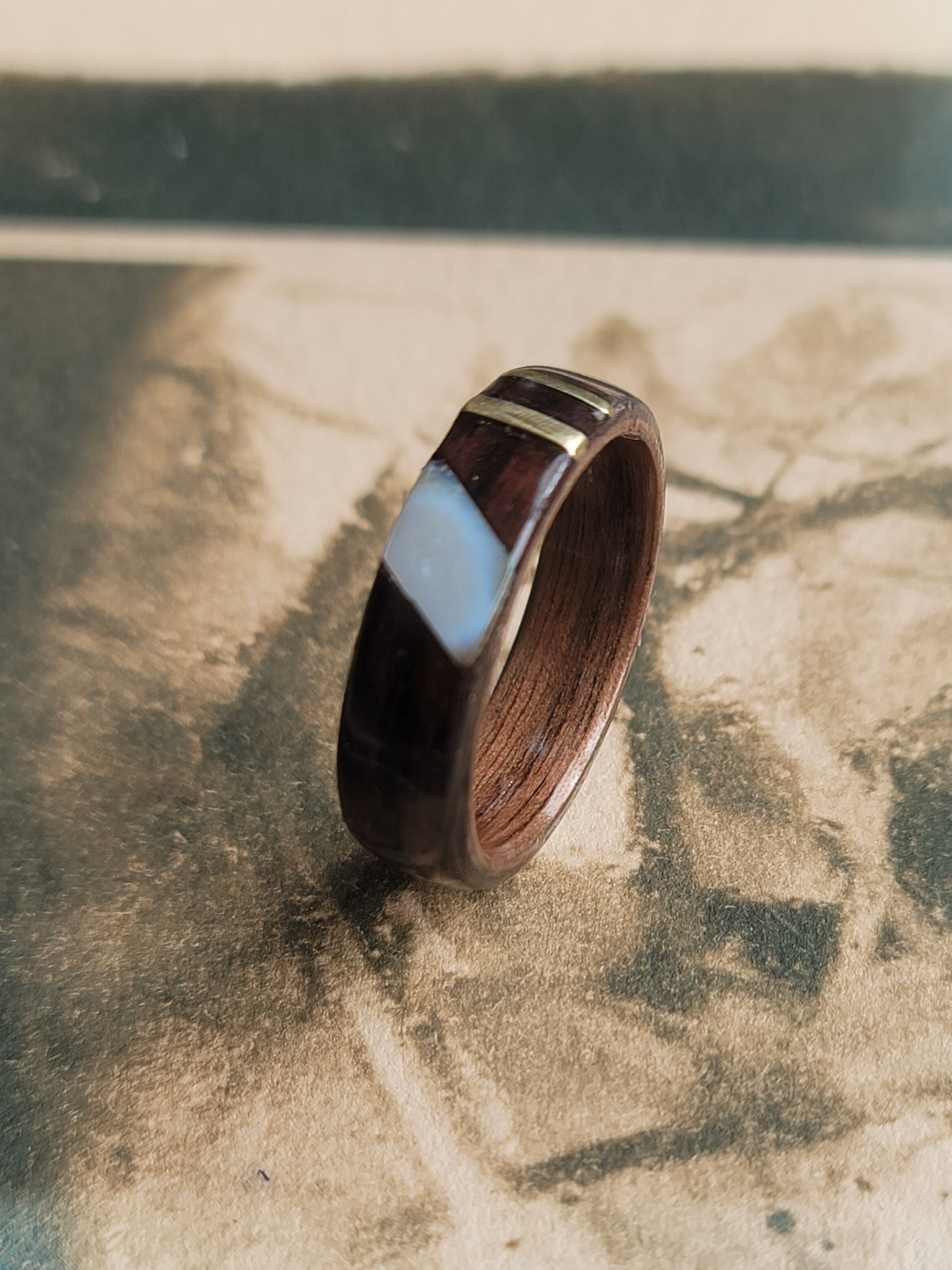 Wooden ring with a metallic accent on a textured surface