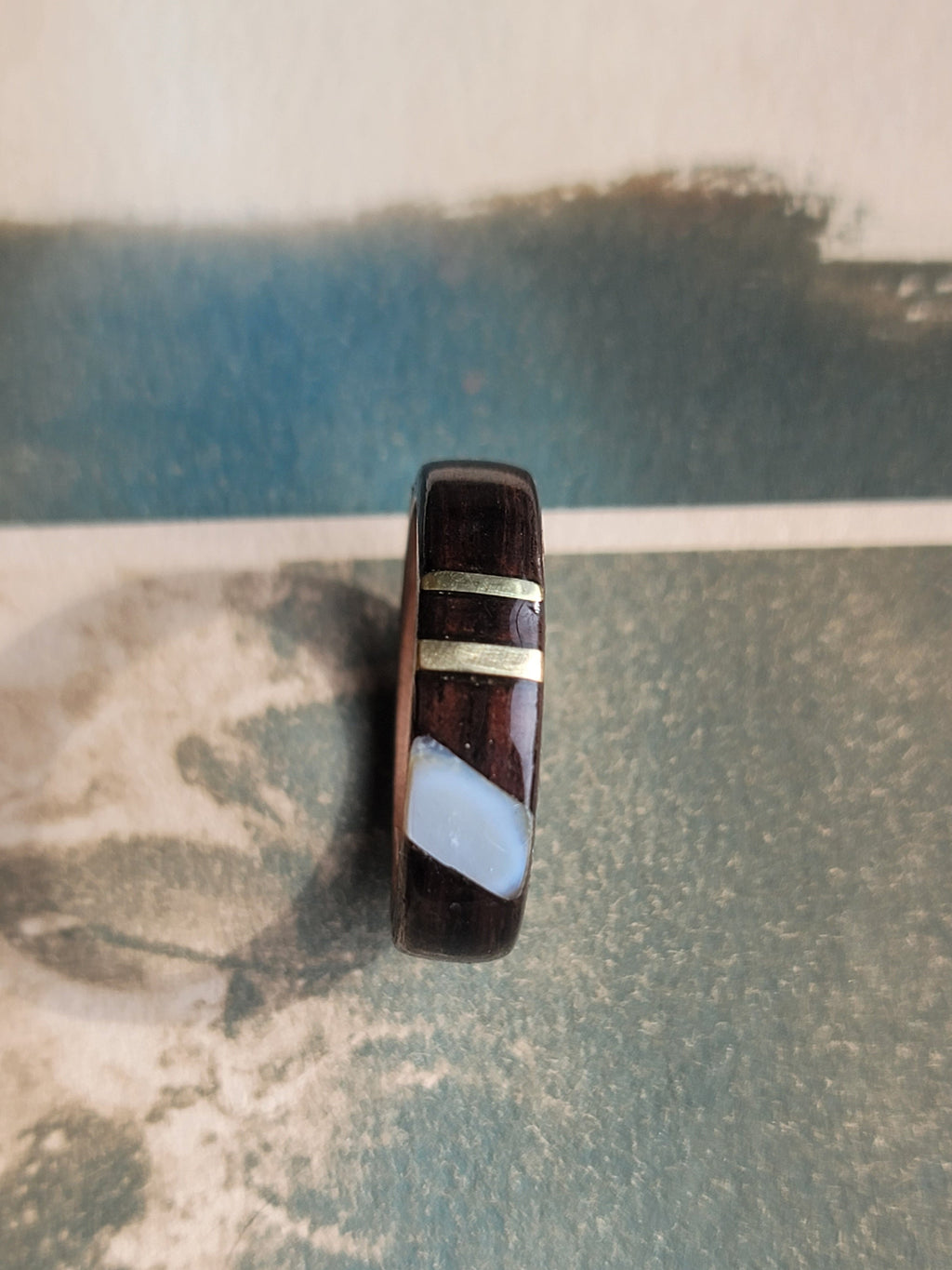 Ring with a striped design on a textured surface