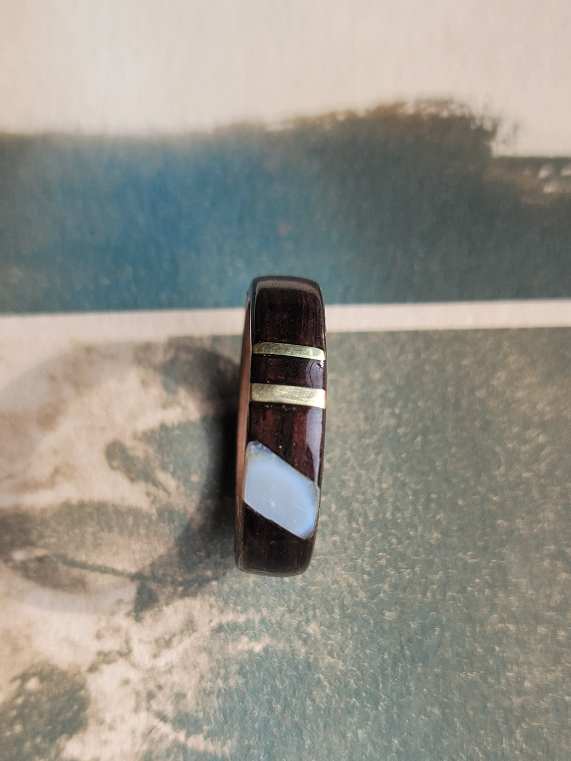 Ring with a striped design on a textured surface