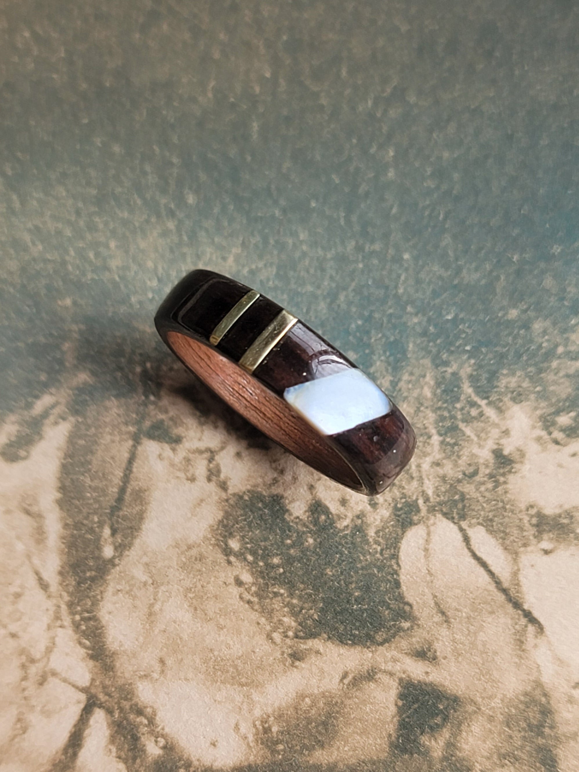 Wooden ring with gold accents on a vintage photograph.