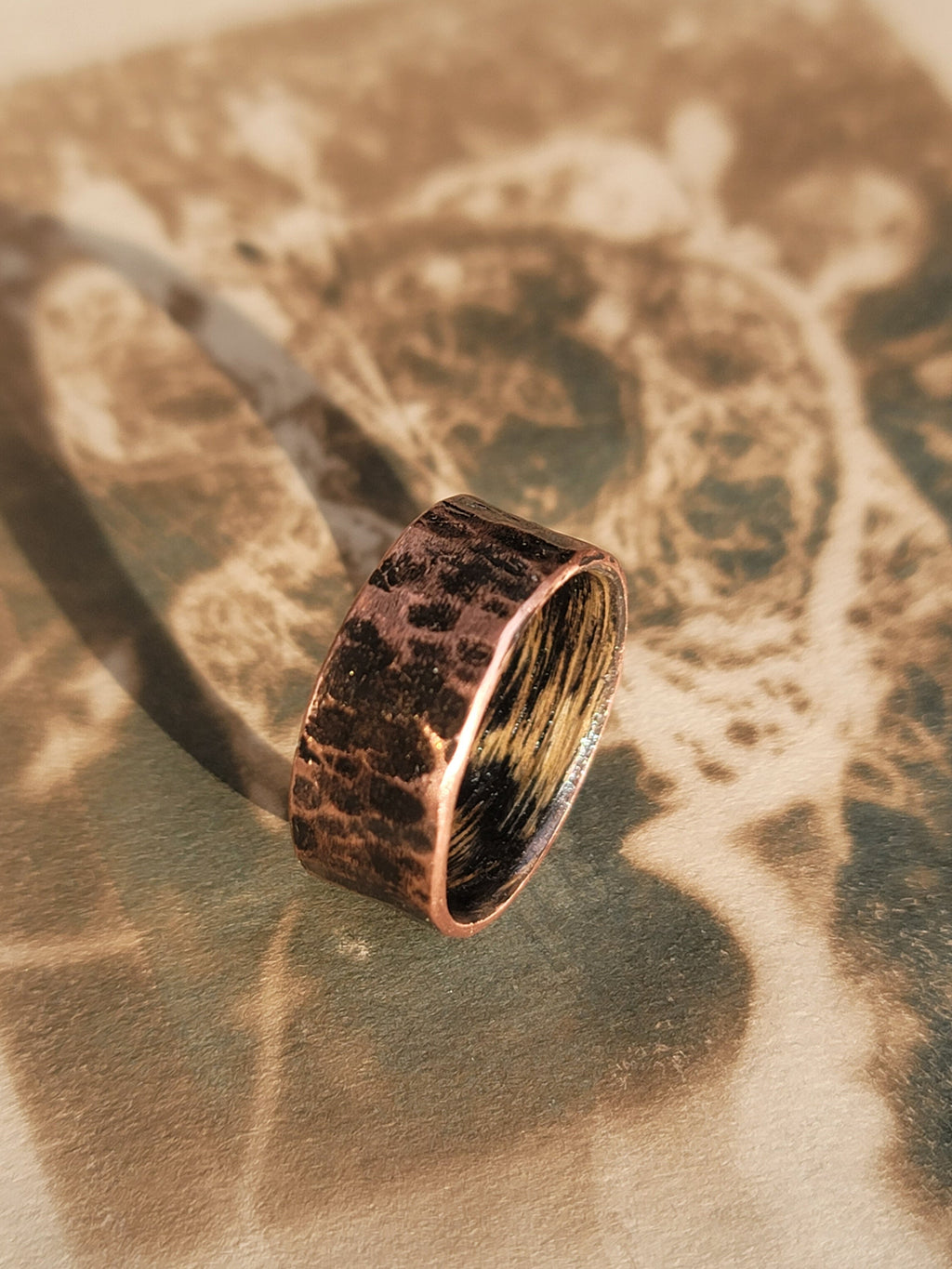 Bronze ring on a textured surface with a blurred background