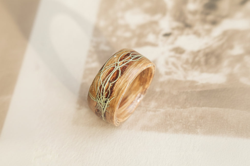 Wooden ring with intricate lichen on a textured surface