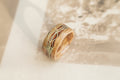 Wooden ring with intricate lichen on a textured surface