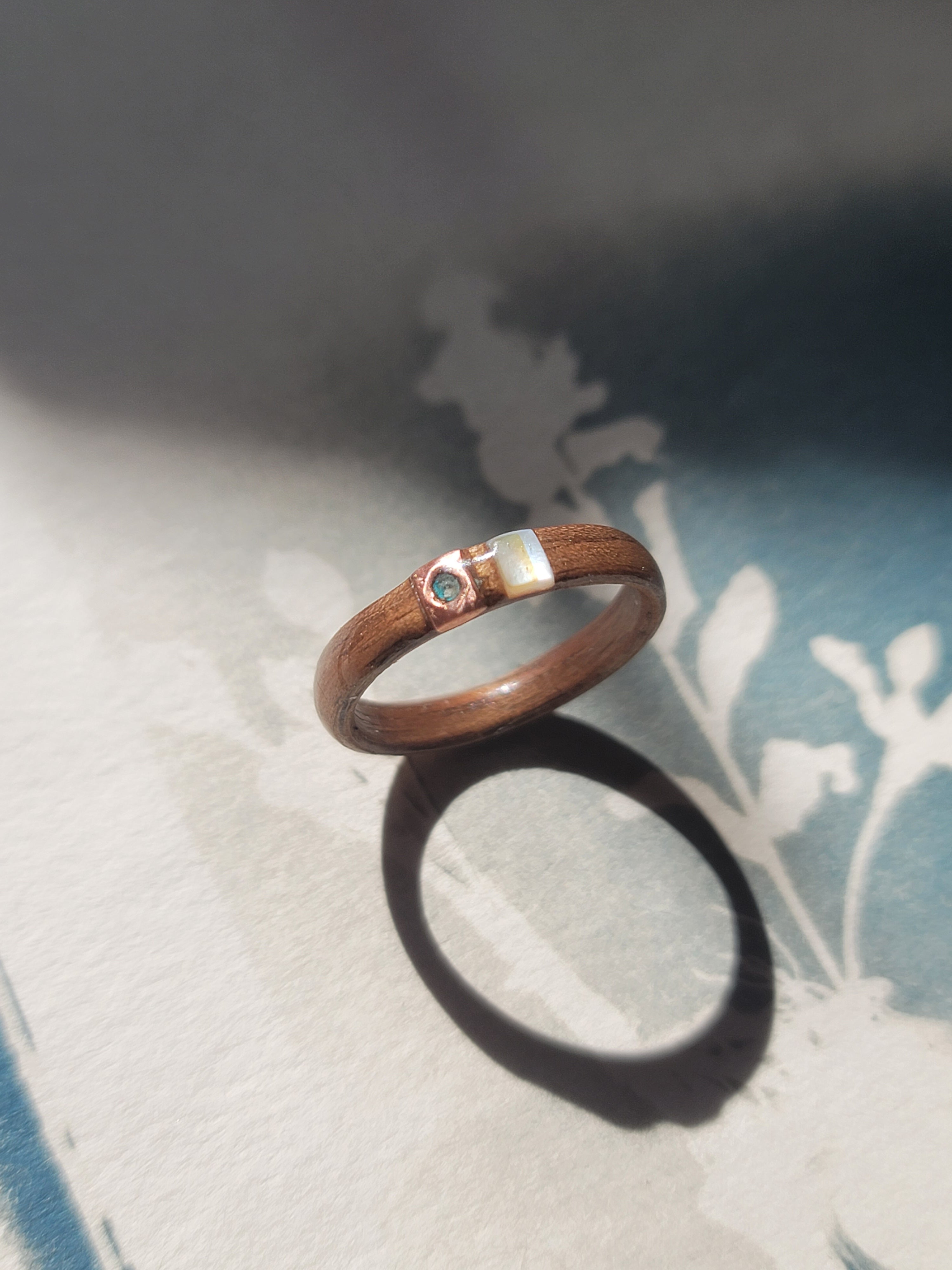 Wooden ring with a small stone on a textured surface