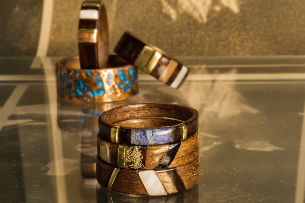 Stack of wooden rings with inlaid stones on a reflective surface